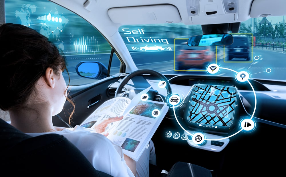 Young woman reading in a self-driving car, showcasing the integration of advanced autonomous vehicle technology.