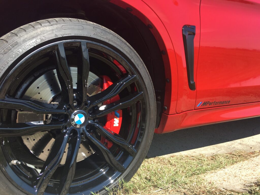 a zoom in of a red car wheel showing a fresh makeover of a car with powder coating at armadillo automotive and powder coating in kenner, louisiana