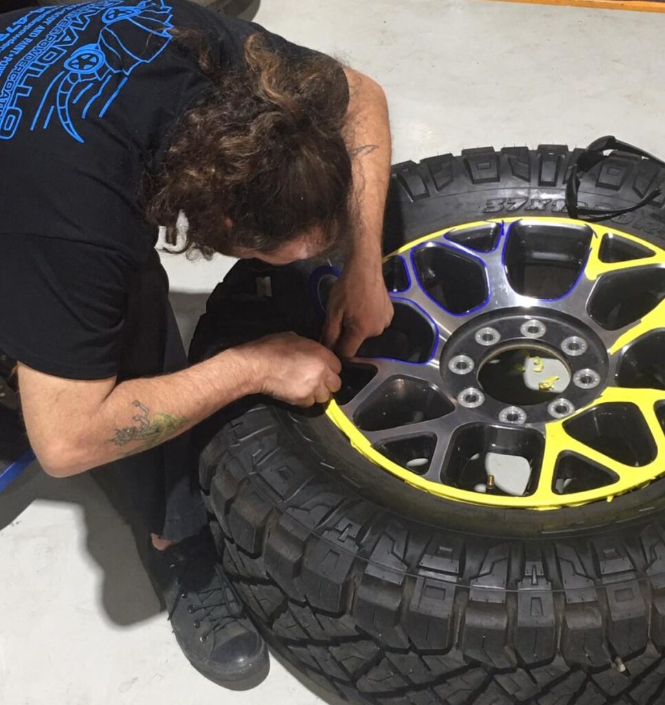 armadillo automotive technician repairing scratched wheels - kenner automotive - armadillo automotive